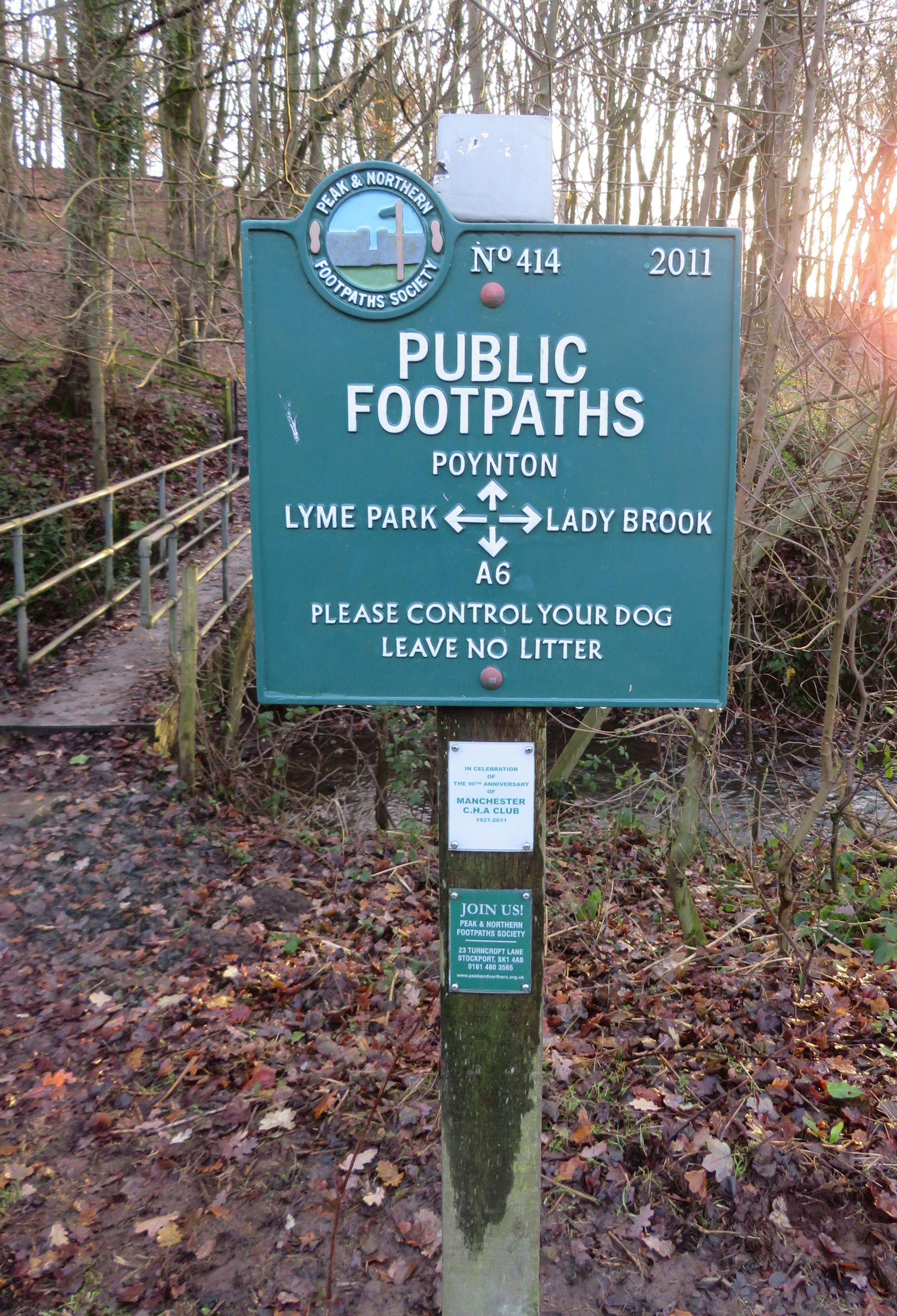 A green cast-iron sign displays the destinations 