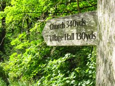A wooden fingerpost reads 