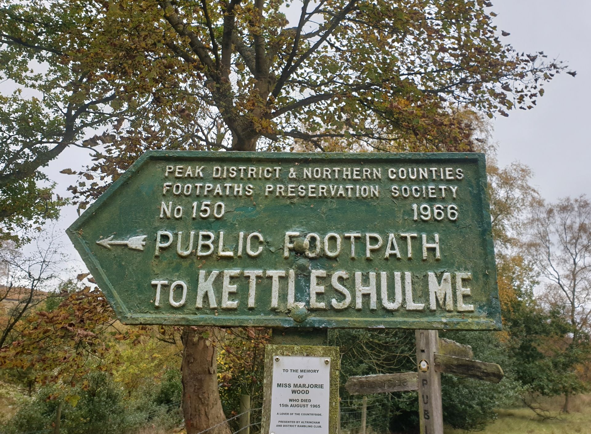 A green cast-iron sign reads 