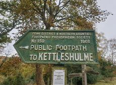 A green cast-iron sign reads 