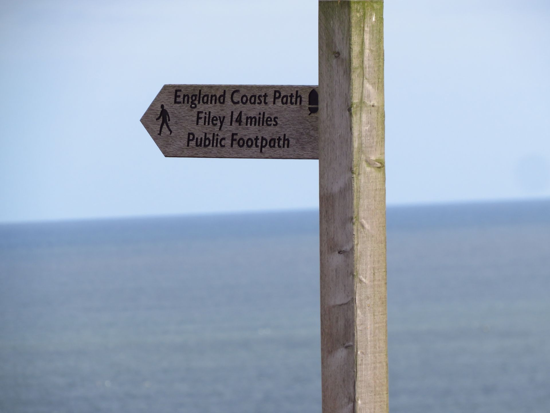 A wooden fingerpost reads 