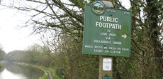 A green cast-iron sign reads 